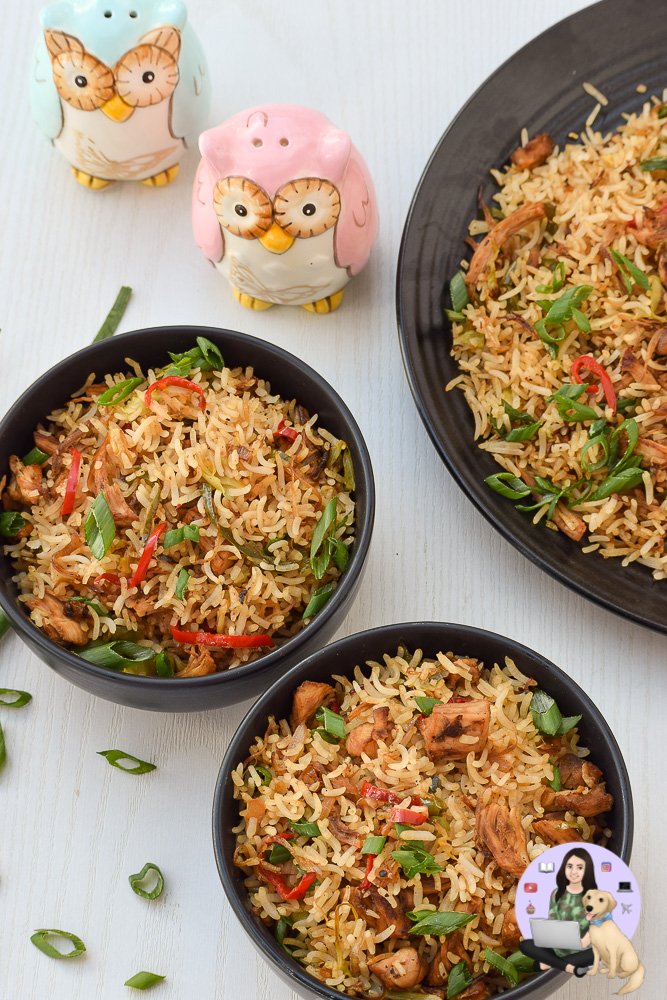 Bowl of chicken fried rice garnished with bias-cut spring onion greens